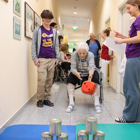 Bewohnerin wirft Dosen mit einem Stoffball